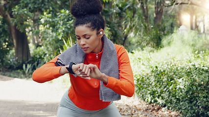 Image showing Woman checking her pulse with a smart watch while on a health, fitness and wellness run in nature. Active girl on a jog for a cardio exercise in an outdoor park with an activity tracker and towel.