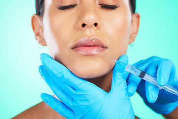 Image showing Woman, face and hands with syringe for plastic surgery, lip implants or botox isolated on a studio background. Hand of doctor with needle injecting filler on female lips for facial cosmetic treatment
