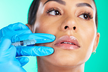 Image showing Woman, face and hands with syringe for botox, plastic surgery or lip implants isolated on a studio background. Hand of doctor with needle injecting filler on female lips for facial cosmetic treatment