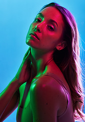 Image showing Glowing skincare, portrait or neon lighting on isolated blue background and hands on neck, body or skin. Beauty model, woman or touching in creative fantasy green, pink or lights aesthetic in makeup