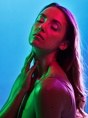 Image showing Woman skincare, glowing or neon lighting on isolated blue background and hands on neck, body or skin. Beauty model, touching or creative fantasy with green, pink lights or makeup cosmetics aesthetic