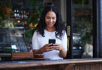 Image showing Woman in coffee shop, cellphone and connection for social media, texting and online reading on break. Female, lady and smartphone for typing, communication and girl in cafe, tea and search internet