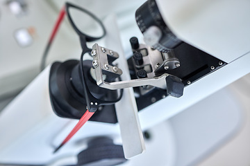 Image showing Optometry, vision and a lens meter in a clinic to measure or adjust the level of eyesight improvement from above. Glasses, eyewear and machine for prescription frame spectacles in a medical office