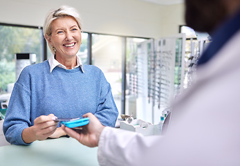 Image showing Eye care, happy customer or payment with a credit card for shopping checkout transaction at optometrist. Finance, zoom or fintech electronic machine purchase or pos by senior woman at a retail store