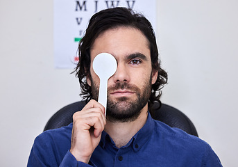 Image showing Portrait, vision and spoon with a man patient at the optometrist for an eye exam testing his depth perception. Healthcare, medical and insurance with a male sitting in the office of an optician