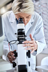 Image showing ophthalmology, microscope and glasses with a woman doctor with tools to check lens for eye care. Medical person at work for science, vision and health insurance while working in lab, store or clinic