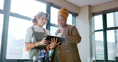 Image showing Digital tablet, women and marketing team doing creative research for a project in their office. Collaboration, teamwork and female business partners checking their company website on a mobile device.