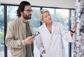 Image showing Optometrist help customer with choice of glasses, vision and lenses in store. Optician, new frames and shelf of spectacles for eye care, consulting and retail shopping services for healthy eyesight