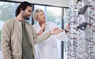 Image showing Woman help man with glasses in optometry store, retail shopping and vision services. Optometrist, eye care and choice of frames, new lenses and shelf for customer consulting, health and wellness test