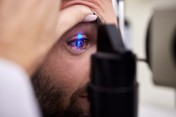 Image showing Eye exam, vision or laser test for a man with machine at optometry consultation for retina problem. Hands, eyesight or doctor helping or checking a patient or client with medical insurance for health