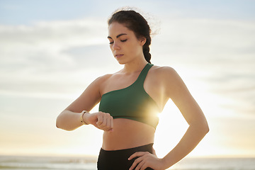 Image showing Smart watch, woman and fitness at sunset on beach for exercise workout, training and nature. Stopwatch, sports and female at sea check time, heart rate and monitor healthy body progress for wellness