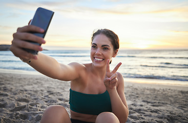 Image showing Selfie, fitness and woman on beach peace sign, live streaming her workout, training or exercise results. Video call of sports, cardio person or gen z influencer relax on sand for runner break by sea