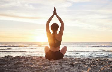 Image showing Woman, yoga and meditation on the beach sunset for zen workout or spiritual wellness outdoors. Female yogi relaxing and meditating in sunrise for calm, peaceful mind or awareness by the ocean coast