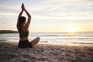 Image showing Woman, yoga and meditation on the beach in sunset for spiritual wellness or zen workout outdoors. Female yogi relaxing or meditating in sunrise for calm, peaceful mind or awareness by the ocean coast