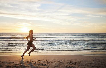 Image showing Woman, fitness and running on the beach in sunset for healthy cardio exercise, training or workout on mockup. Female runner exercising in sunrise for run, health and wellness by the ocean coast