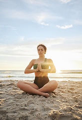 Image showing Woman, yoga and meditation on the beach in namaste for spiritual wellness or zen workout in the sunset. Female yogi relaxing and meditating for calm, peaceful mind or awareness by the ocean coast