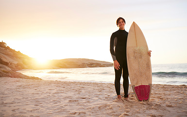 Image showing Surfer, portrait and man with surfboard at the sea, beach and ocean in sunset or the morning with mockup space. Young, ready and male in swimsuit on a sunny surf day on the sand, shore and water