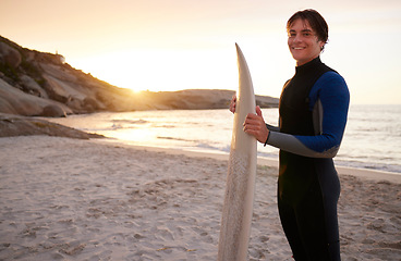 Image showing Surfer, surf and portrait of teenager with surfboard at the beach, sea and ocean in sunset with mockup space. Young, ready and male in swimsuit on a sunny day on the sand, shore and water in summer