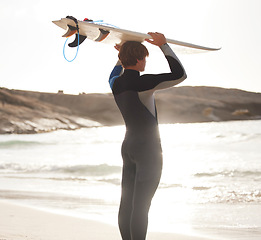 Image showing Surfer on beach, sun and man with surfboard on head, looking at ocean view with travel and nature mockup. Adventure, surfing at sunrise and outdoor with athlete, extreme sport and active lifestyle