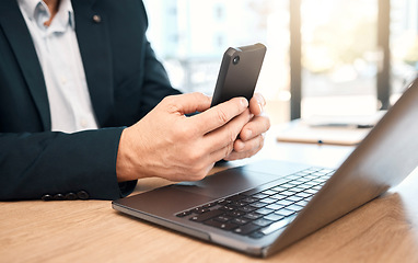 Image showing Hands, phone and laptop with a business man doing research in his office while typing a text message. Mobile, communication and networking with a male manager or employee reading an email at work