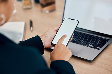 Image showing Woman, hands and phone by laptop on mockup for communication, social media or mobile app at office desk. Hand of female touching green screen display on smartphone for online advertising or marketing