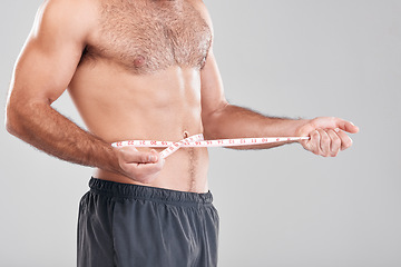 Image showing Health, fitness and man with measuring tape on waist, healthy diet and exercise for body care. Sports, nutrition and stomach, tracking weight loss and six pack progress isolated on grey background.