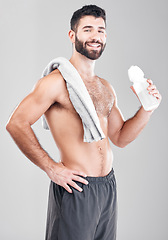 Image showing Portrait, exercise and man with towel, water bottle and training on grey studio background. Canada, face and happy male athlete with liquid after practice, healthy lifestyle and workout for wellness