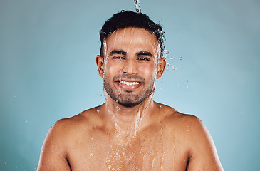 Image showing Portrait, wet and man with water, cleaning and hygiene with guy on blue studio background. Face, male and gentleman with liquid, aqua or washing for skincare, morning routine or grooming on backdrop