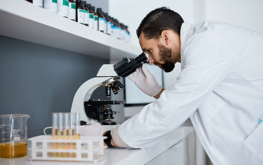 Image showing Science, microscope and innovation with a doctor man at work in a laboratory for research or development. Medical, analytics and biotechnology with a male scientist working in a lab for breakthrough