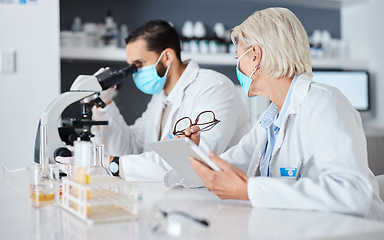 Image showing Scientist teamwork, lab and covid 19 vaccine research for pharma company with mask, ppe and tablet. Man, woman and science with microscope analysis, advice and goals to stop global virus with results