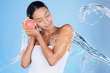 Image showing Beauty model, water splash or skincare grapefruit on blue background in facial hydration, healthcare or isolated wellness. Black woman, happy or wet with citrus food for vitamin c or face dermatology