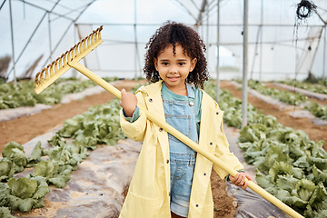 Image showing Kid, girl or portrait and farming tool in greenhouse, agriculture land or sustainability field for harvesting. Smile, happy or gardening kid and farmer equipment for soil, lettuce or vegetable growth