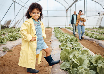 Image showing Kid, happy or girl in farming portrait, akimbo or hands on hips in greenhouse, agriculture land or sustainability field pride. Smile, child or learning gardening in countryside nature or lettuce agro