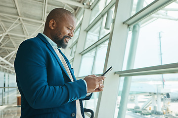 Image showing Black man, phone and chatting at airport for business travel, trip or communication waiting for flight. African American male smile for conversation, schedule or checking plain times on smartphone