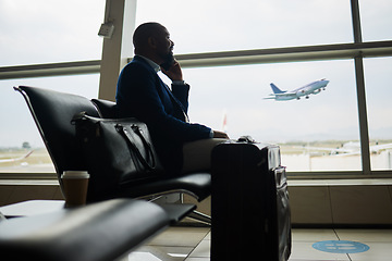 Image showing Black man, phone call and luggage at airport for business travel, trip or communication waiting for flight. African American male in conversation or discussion on smartphone ready to board airplane