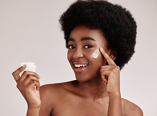 Image showing Skincare, product and portrait of black woman with cream on face, smile and advertising skin care promotion. Dermatology, cosmetics and facial for happy model with jar isolated on studio background.