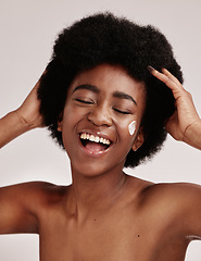 Image showing Skincare, beauty and black woman with afro and cream on face, smile and advertising luxury skin product promotion. Dermatology, cosmetics and spa facial for happy model isolated on studio background