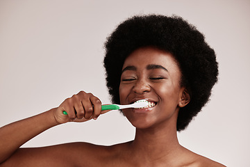 Image showing Brushing teeth, toothbrush and black woman for cleaning mouth on studio background. Face of happy person advertising dentist tips for dental care, hygiene and clean smile for healthy lifestyle