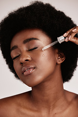 Image showing Face serum, skin care and beauty of black woman in studio with dermatology cosmetic oil. Aesthetic model with hands for collagen product for health, wellness and facial skin natural youth glow