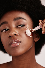 Image showing Face roller, skin care and black woman facial massage in studio with dermatology and cosmetic tools. Aesthetic model with hands for spa product for health, wellness and natural youth skin glow