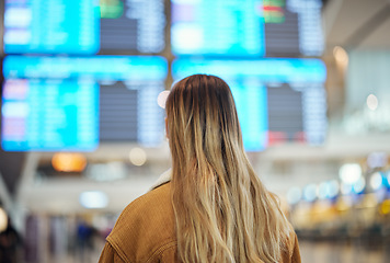 Image showing Woman, airport and reading board, screen and flight schedule for travel, plane and adventure with back. Girl, immigration and global transportation in lobby for airplane time, departure or arrival