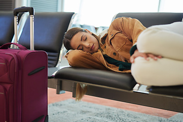 Image showing Tired, sleeping and woman at airport, waiting and bench for travel, international transport and flight delay. Tourist nap on chair at airplane lounge before journey with baggage, luggage and suitcase