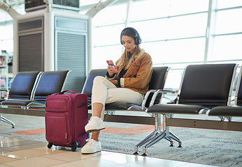 Image showing Headphones, music phone and woman in airport lobby on social media, internet browsing or web scrolling. Travel flight, mobile technology and female with smartphone app for streaming radio or podcast.