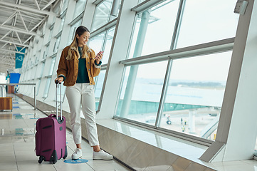 Image showing Luggage, travel and woman with phone at airport for social media, web scrolling or internet browsing. Suitcase, mobile and happy female on smartphone for networking while waiting for flight departure