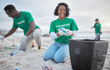 Image showing Volunteer group, beach clean and recycling plastic bottle for community service, pollution and earth day. Black woman and man ngo team cleaning sand for climate change, nature and helping environment