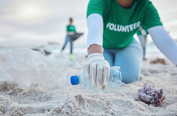 Image showing Hands, plastic and volunteer at beach cleaning for environmental sustainability. Recycle, earth day and woman or charity activist picking up bottle, trash and garbage for recycling to stop pollution.