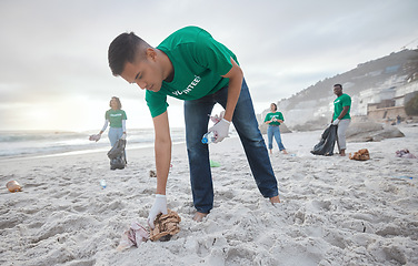 Image showing Teamwork, cleaning and recycling with man on beach for sustainability, environment and eco friendly. Climate change, earth day and nature with volunteer for community service, pollution and plastic