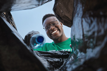 Image showing Recycle, smile and black man with view in bag, sustainability and cleaning plastic pollution, earth day and help in community. Saving the environment, charity and people putting trash in garbage bin.