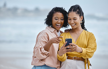 Image showing Phone, beach and social media with black woman friends outdoor together by the ocean or sea in the morning. Nature, mobile or internet with a young female and friend reading a text on the coast