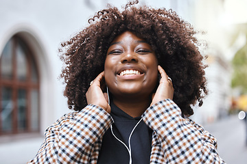 Image showing Freedom, city and black woman listening to music, radio or song in the street while walking to work. Happy, smile and African female streaming playlist, album or audio with earphones in road in town.